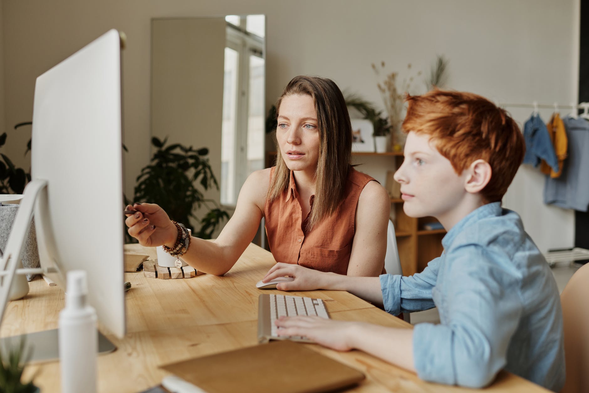 photo of woman tutoring young boy