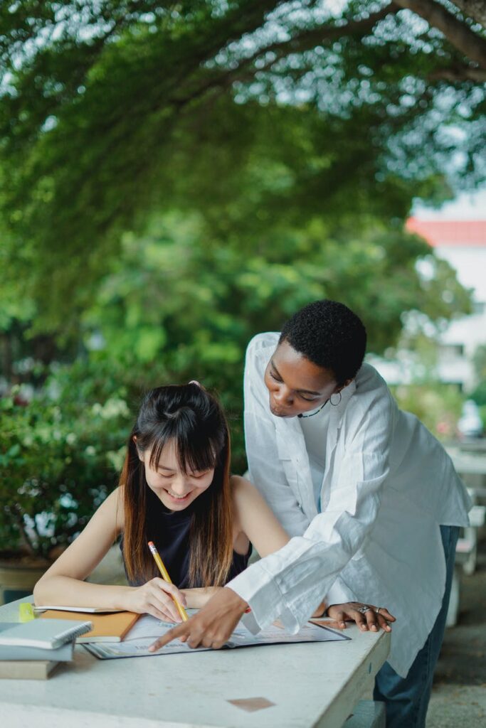 multiethnic female students preparing for exam in park